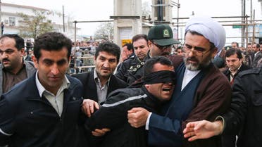 Iranian officials and security escorting away the blindfolded man Bilal from the scene of his execution in public in the northern city of Nour, Iran. (File: AP)