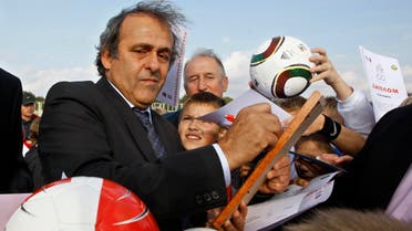 UEFA President Michel Platini, left, signs autographs after attending a ceremony to mark the start of construction of a national soccer team training center in Minsk, Belarus, Tuesday, Oct. 4, 2011. Platini is in Belarus to mark 100-years of Belarusian soccer. (AP Photo/Sergei Grits)