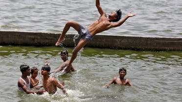 Boys cool off themselves in the waters of the river Sabarmati on a hot summer day in Ahmedabad, India, May 24, 2015. Temperature in Ahmedabad on Sunday reached 43 degree Celsius (109.4 degree Fahrenheit), according to India's metrological department website. REUTERS/Amit Dave