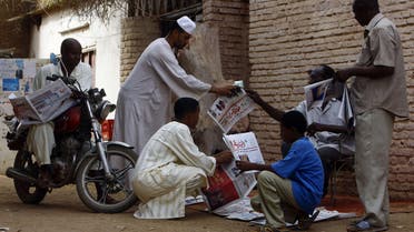 Sudanese men gather around a newspaper street vendor in a street in Al-Jarif city, outside the capital Khartoum, on May 25, 2015. Sudanese security forces seized the Monday print runs of nine newspapers and suspended the publishing licences of four of them in a major media crackdown, according to editors and an NGO. AFP PHOTO / ASHRAF SHAZLY