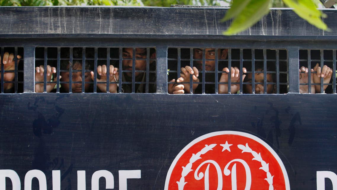 Detained anti-government activists peer out from a prison van after their court appearance in Islamabad, Pakistan, Saturday, Sept. 13, 2014. Pakistan's opposition said police have arrested scores of activists in an effort to stop them from participating in weekslong sit-ins in the capital, Islamabad. (AP Photo/Anjum Naveed)