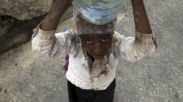 An internally displaced girl carries water on her head in the district of Khamir of Yemen's northwestern province of Amran. (Reuters)