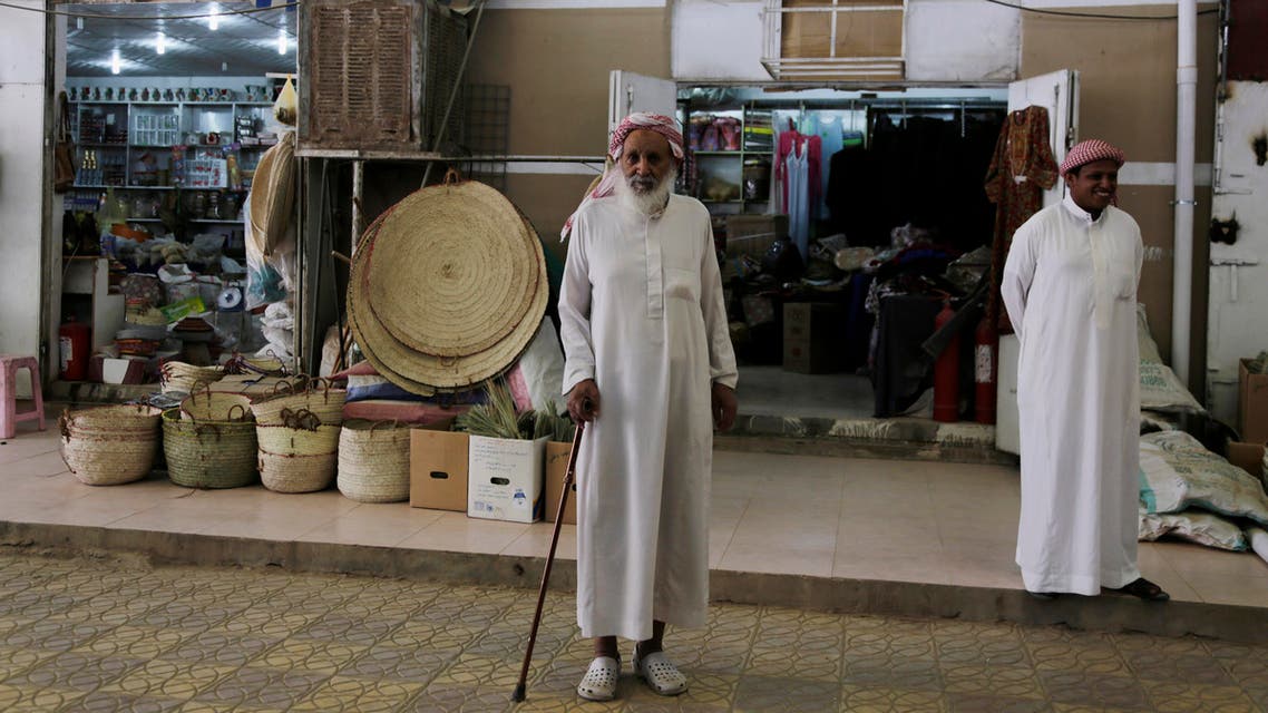 In this photo taken on April 22, 2015, Saudi merchants stand in front of stores in the old market in Najran, Saudi Arabia. The country is now leading an offensive against the Shiite Houthi rebels in Yemen, who are supported by its arch-rival Iran. Much of the kingdom, however, continues on its prosperous way, as reflected in interviews by The Associated Press with more than two dozen people. (AP Photo/Hasan Jamali)