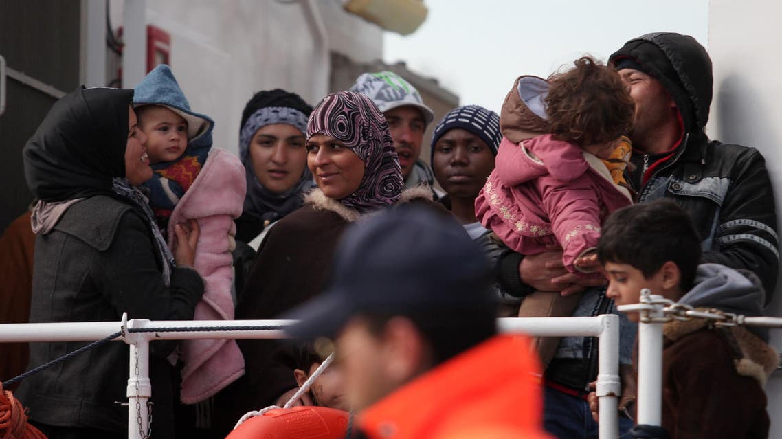 FILE - In this Wednesday, March 4, 2015, file photo rescued migrants wait to disembark from an Italian Coast Guard vessel in Porto Empedocle, Sicily, southern Italy. In a dramatic sea rescue north of Libya, a flotilla of rescue ships saved nearly 1,000 migrants and refugees, while 10 migrants perished in the southern Mediterranean. European Union countries are immersed in a full-fledged migration crisis. With the EU lacking funds and resources, some officials are even floating the idea of a multinational border guard to deal with arrivals of hundreds of thousands from war-torn countries like Syria, poor African nations and non EU neighbors like Kosovo. (AP Photo/Francesco Malavolta, File)
