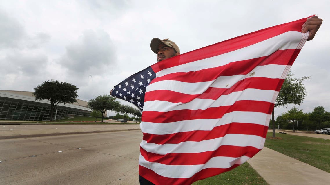 Joseph Offutt, 20, holds a U.S. flag across the street from the Curtis Culwell Center, where ISIS claimed responsibility for an attack by two gunmen. (File: AP)