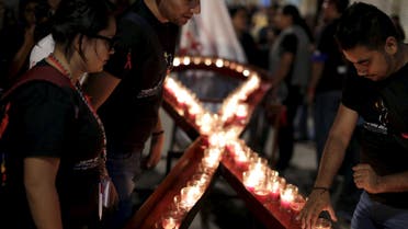 People place candles in the shape of an HIV/AIDS awareness "Red Ribbon" during the "Candlelight Memorial" in downtown Guatemala City. (File: Reuters)