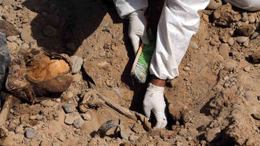 An Iraqi forensic worker excavates human remains in a mass grave, believed to contain the bodies of Iraqi soldiers killed by ISIS militants when they overran. (File: AP)
