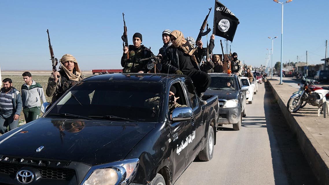 In this photo released on May 4, 2015, by a militant website, which has been verified and is consistent with other AP reporting, Islamic State militants pass by a convoy in Tel Abyad town, northeast Syria. In contrast to the failures of the Iraqi army, in Syria Kurdish fighters are on the march against the Islamic State group, capturing towns and villages in an oil-rich swath of the country's northeast in recent days, under the cover of U.S.-led airstrikes. (Militant website via AP)