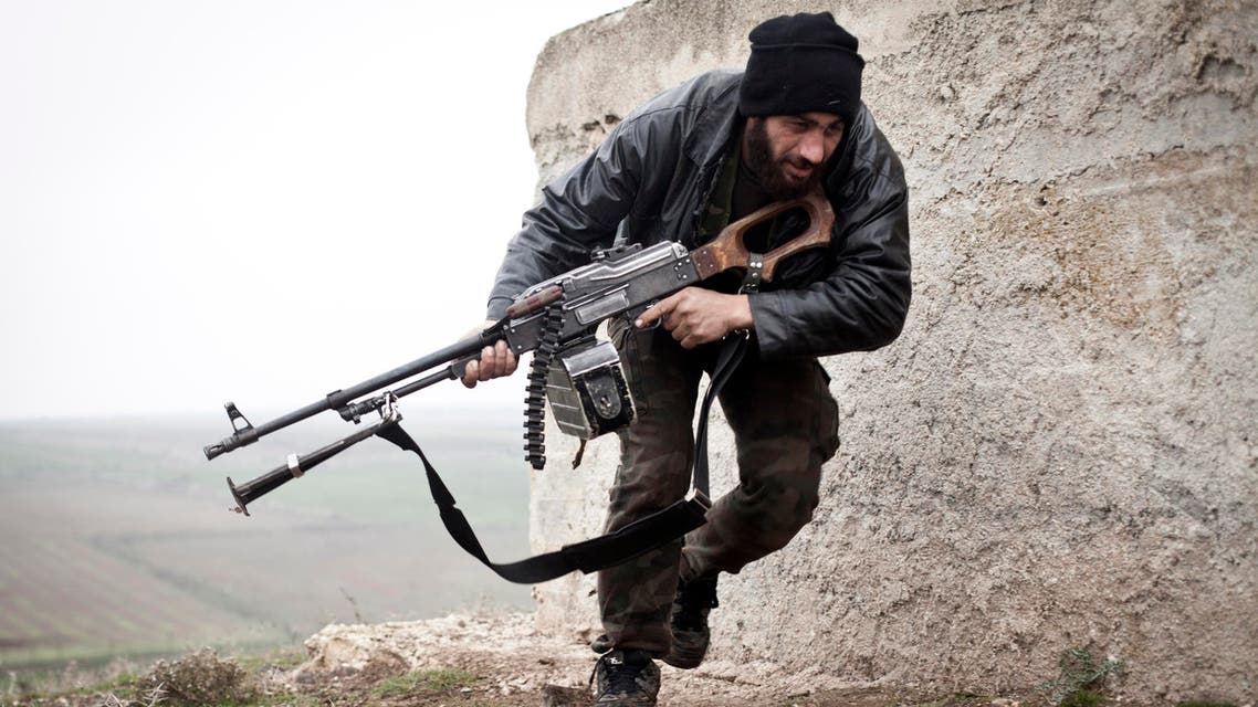 A Free Syrian Army fighter takes cover during fighting with the Syrian Army in Azaz, Syria. (AP)