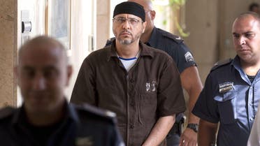 A file picture taken in Jerusalem on June 20, 2012, shows Palestinian Abdallah Barghouti, a leading commander for the Ezzedine al-Qassam Brigades, the armed wing of Hamas in the West Bank, being is escorted by Israeli police into the Magistrate's Court for a hearing. AFP