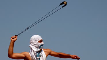 A Palestinian protester hurls stones at Israeli soldiers during a protest against the expansion of the nearby Jewish settlement of Halamish, in the West Bank village of Nabi Saleh near Ramallah, Sept 28, 2012. (AP)