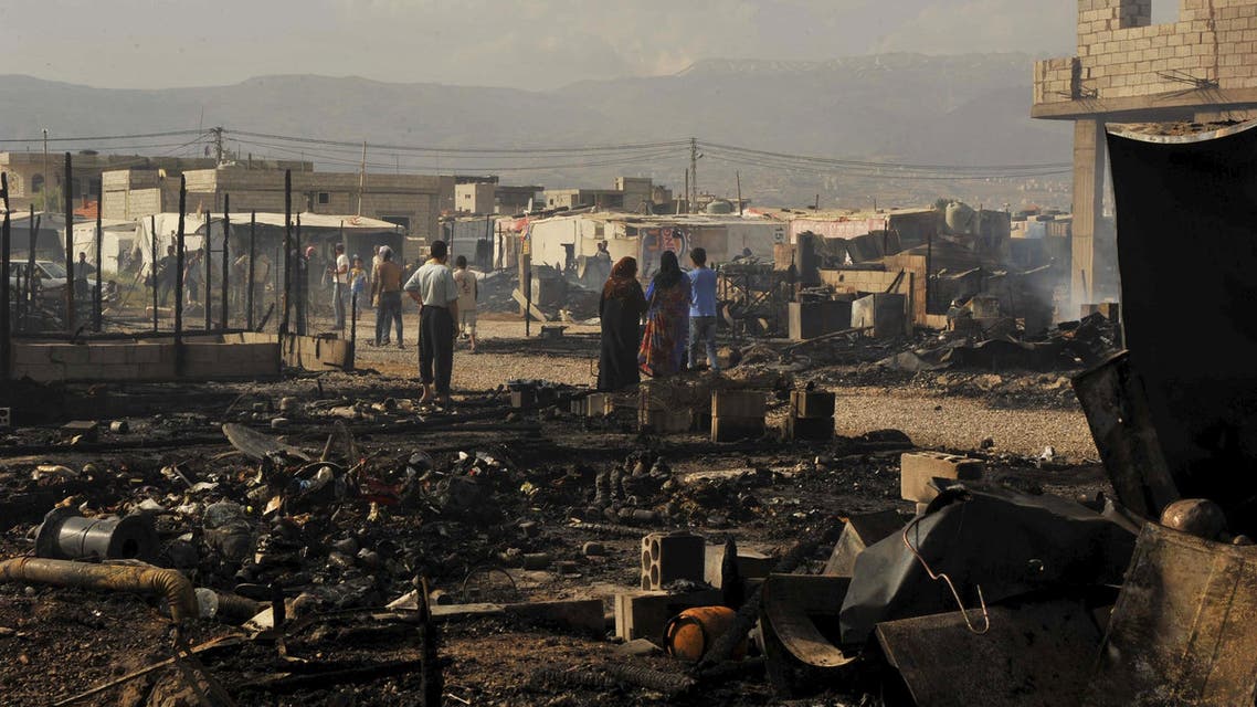 People inspect the tents that were burnt in a refugee camp for Syrian refugees in Lebanon's Bekaa Valley June 1, 2015. (Reuters)