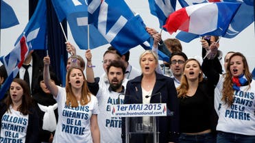 France’s far-right National Front president Marine Le Pen, center, surrounded by supporters sing the French National Anthem after her speech at Opera Plaza during the annual May Day march, in Paris, France, Friday, May 1, 2015. France’s far-right National Front is holding its annual May Day march, but for the first time the party’s founder Jean-Marie Le Pen is not taking a seat at the tribune. (AP Photo/Francois Mori)