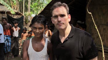 In this Friday, May 29, 2015 photo, American actor Matt Dillon, right, shakes hands with Noor Alam, a 17-year old Rohingya survivor of human-trafficking at Thetkabyin village, north of Sittwe in the western state of Rakhine, Myanmar. Dillon puts a rare celebrity spotlight on the plight of Myanmar's long-persecuted Rohingya Muslims, visiting a hot, squalid camp for tens of thousands displaced by violence and a port that has served as one of the main launching pads for their exodus by sea. (AP Photo/Robin McDowell)