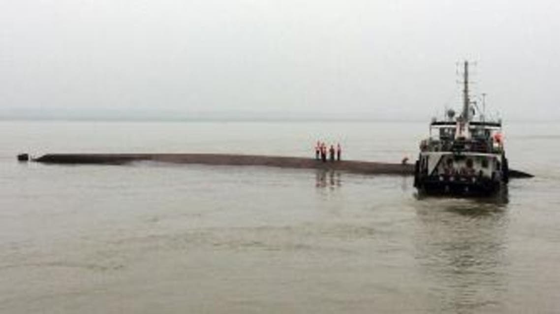 BEJ3211 - YANGTZI RIVER, Hubei, CHINA : A Chinese rescue boat is seen alongside a capsized passenger ship carrying more than 450 people which sunk in the Yangtze river, triggering a rescue effort hampered by strong winds and heavy rain off Jianli in China's Hubei province on June 2, 2015. The ship named Dongfangzhixing, or "Eastern Star", was headed from the eastern city of Nanjing to the southwestern city of Chongqing when it sank in the Jianli section of the river. CHINA OUT AFP PHOTO