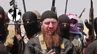 This image made from undated video posted during the weekend of June 28, 2014 on a social media account frequently used for communications by the Islamic State, which has been verified and is consistent with other AP reporting, shows Omar al-Shishani standing next to the group's spokesman among a group of fighters as they declare the elimination of the border between Iraq and Syria. In the Pankisi, the mountainous region of northeastern Georgia where he was born in 1986, the ginger-bearded commander is a hero and a role model. Following the path he blazed, as many as 200 of his young countrymen have left their villages. (Militant social media account via AP)