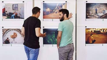 Alon Sahar (L) and Shay Davidovich, both former Israeli army soldiers, discuss in front of photographs at an exhibition of the Israeli NGO "Breaking the Silence" at the Kulturhaus Helferei in Zurich (Photo: AFP)