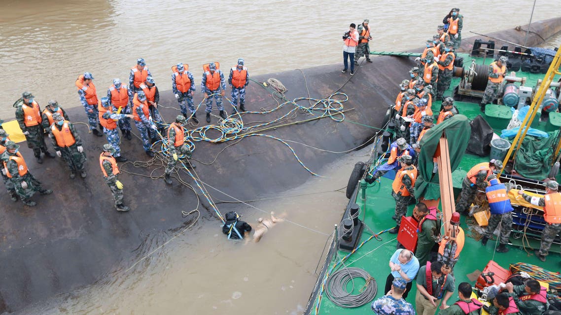 Rescue personnel and divers retrieve the body (C) of a passenger who was travelling on the capsized passenger ship Dongfangzhixing or "Eastern Star" in the Yangtze river at Jianli in China's Hubei province on June 3, 2015. AFP