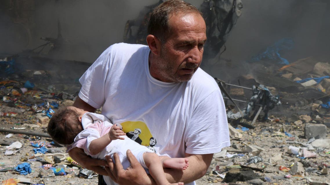 A man holds a baby that survived what activists said was a site hit by a barrel bomb dropped by forces loyal to Syrian President Bashar al-Assad at the old city of Aleppo, (Reuters)