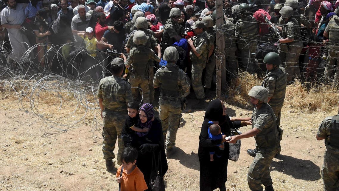 Turkish soldiers help Syrian refugees as they cross into Turkey on the Turkish-Syrian border, near the southeastern town of Akcakale in Sanliurfa province, Turkey. (Reuters)