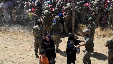Turkish soldiers help Syrian refugees as they cross into Turkey on the Turkish-Syrian border, near the southeastern town of Akcakale in Sanliurfa province, Turkey. (Reuters)