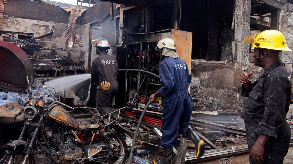 Firefighters spray water over the smoldering remains a gas station following an explosion in Accra, Ghana, Thursday, June 4, 2015. AP