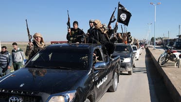Islamic State militants pass by a convoy in Tel Abyad town, northeast Syria. AP