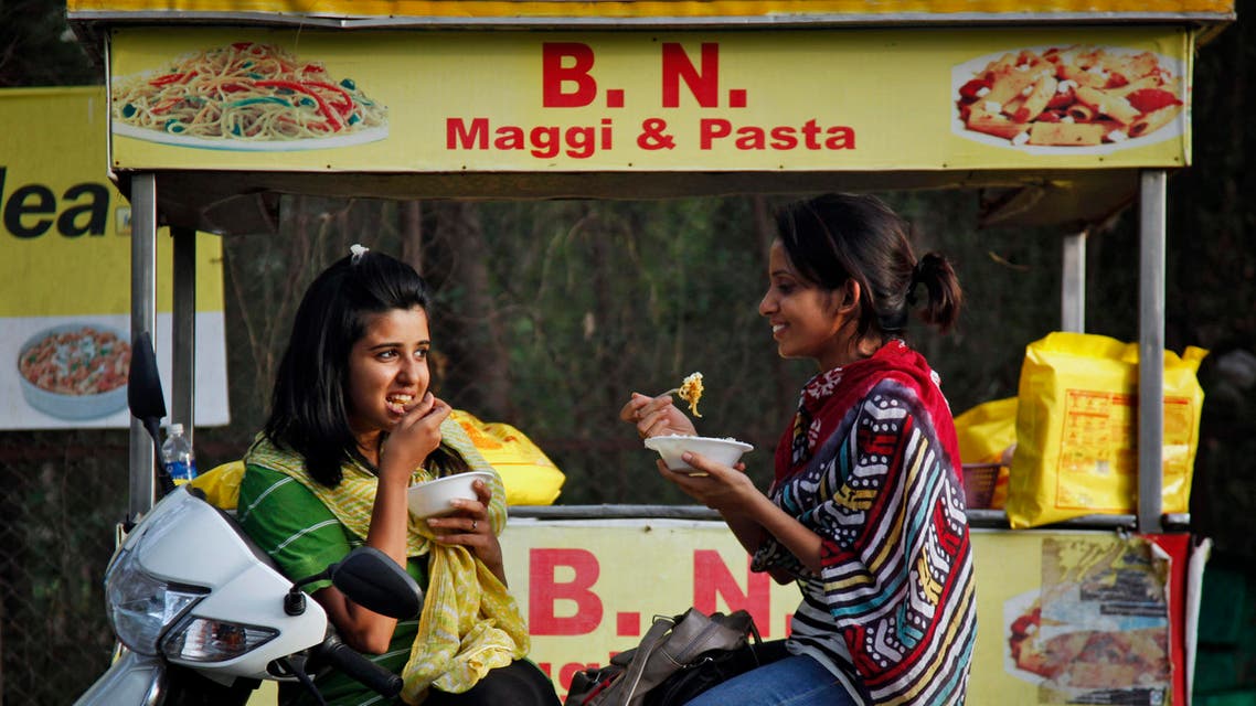Indian girls eat noodles at a roadside stall in Ahmadabad, India, Thursday, June 4, 2015. Indian shopkeepers withdrew a popular brand of Nestle instant noodles “Maggi” from their shelves on Wednesday, June 3, 2015, after tests revealed the snack contained unsafe levels of lead. (AP Photo/Ajit Solanki)