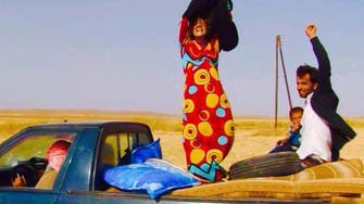 Women escaping ISIS victoriously remove black clothing 