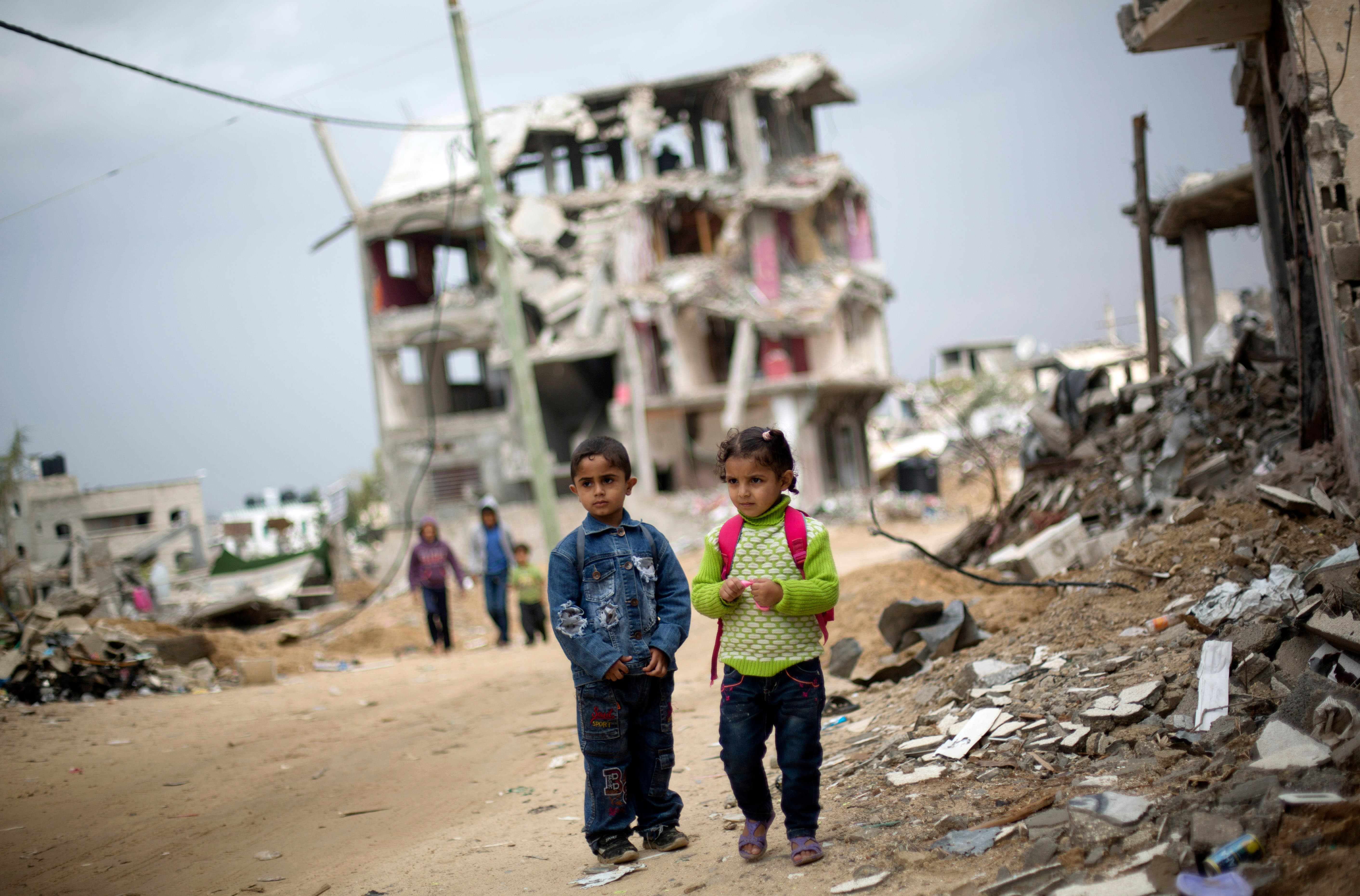 Palestinian school children walk through destroyed houses in Gaza City's Shijaiyah neighborhood, Sunday, Oct. 19, 2014. (AP)
