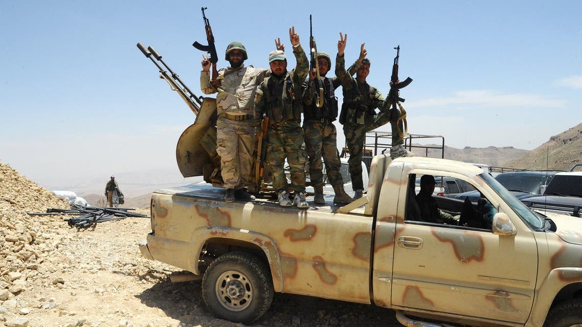 HO01 - Damascus, -, SYRIA : A handout picture released by the Syrian Arab News Agency (SANA) on June 6, 2015 shows Syrian pro-government fighters flashing the sign for victory at a hilltop in the Qalamoun region on the outskirts of the Syrian capital Damascus. The chief of Lebanon's Shiite militia Hezbollah, Hassan Nasrallah, said his fighters had managed to "liberate dozens of square kilometres" in the Qalamun region straddling the Syrian-Lebanese border, pushing back Al-Nusra Front, Al-Qaeda's affiliate in Syria, and its allies. AFP PHOTO / HO / SANA