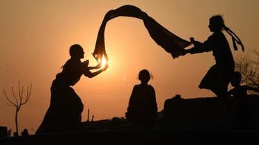 Pakistani girls are silhouetted as they play at a slum area of Lahore on March 4, 2015. In Pakistan's conservative patriarchal society daughters are often considered a burde