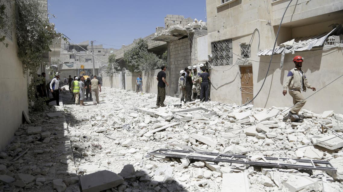 Civilians and civil defense members inspect a site hit by what activists said was a sea mine dropped by forces loyal to Syria's President Bashar al-Assad in Maaret al-Naaman town in Idlib province June 4, 2015. REUTERS/Khalil Ashawi