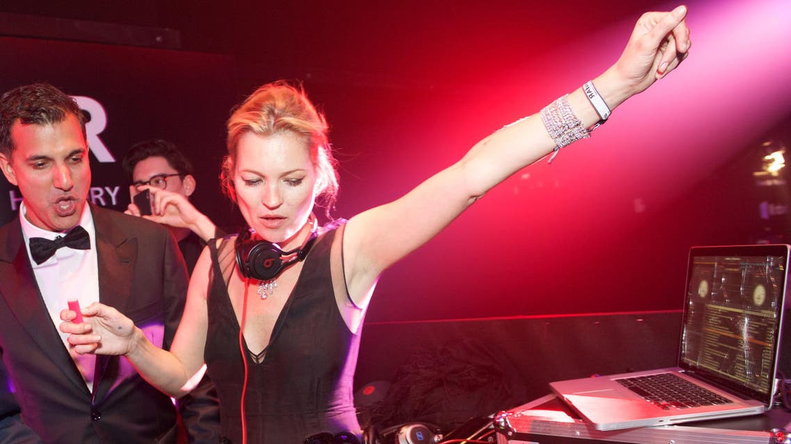 Kate Moss, right, plays DJ at the inaugural amfAR Hong Kong gala on Saturday, March 14, 2015 in Hong Kong. (AP)