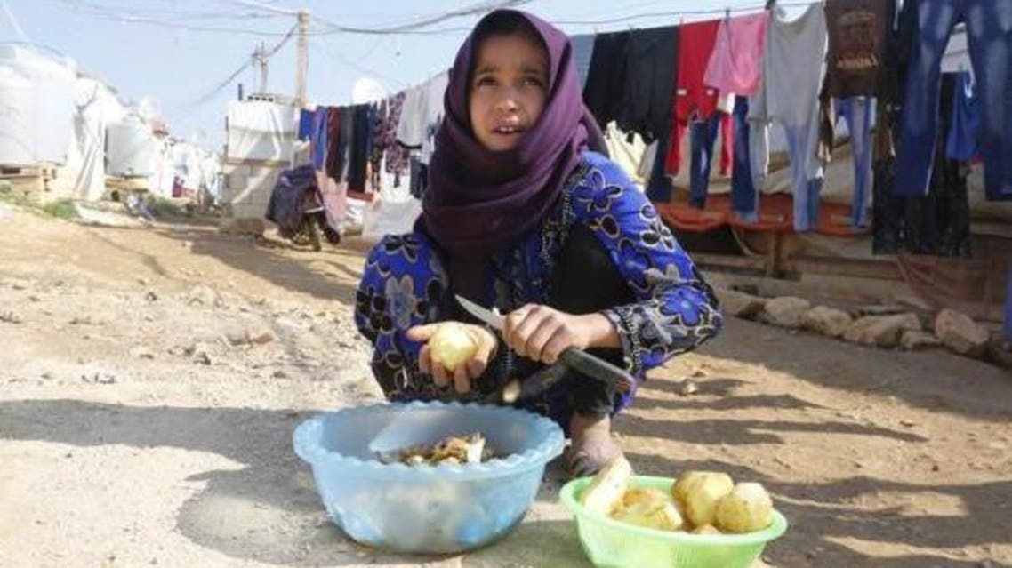 A Syrian refugee peels potatoes at a refugee camp in Zahle in the Bekaa valley, Lebanon. November 18, 2014. REUTERS/Mohamed Azakir