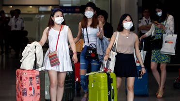 Passengers flying from Seoul, South Korea, wear masks as a precaution against MERS, Middle East Respiratory Syndrome, as they arrive at Hong Kong Airport Tuesday, June 9, 2015. (AP)