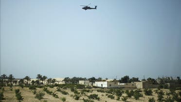 A military helicopter conducts an aerial patrol above Sheikh Zuwayed city