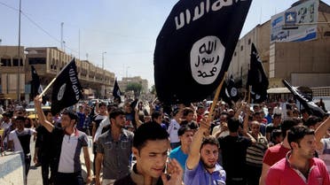 pro-Islamic State group slogans as they wave the group's flags in front of the provincial government headquarters in Mosul. (AP)