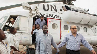 A member of the joint U.N. African Union Mission in Darfur (UNAMID), right, escorts three freed humanitarian workers out of a U.N. helicopter as they landed in Darfur, July 19, 2014. (File Photo: AP) 