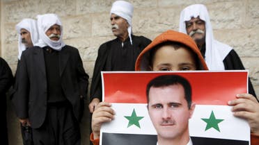 A picture shows a boy holding a flag with the image of Syria's President Assad during a rally in a Druze village on the Golan Heights. (File Photo: Reuters)