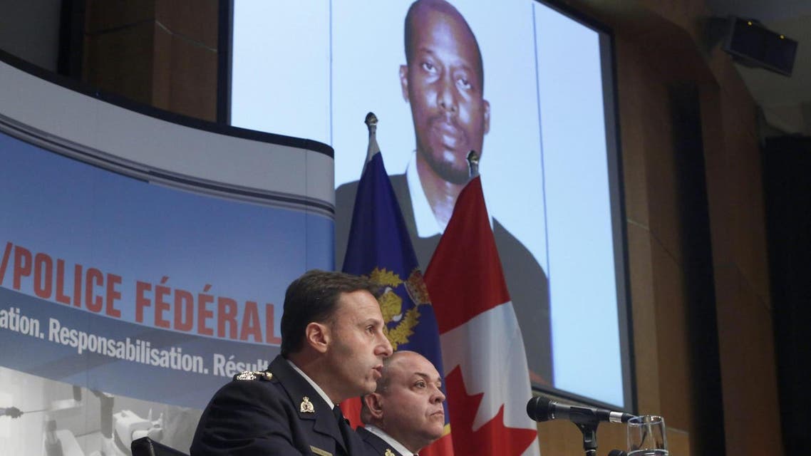 Royal Canadian mounted police assistant commissioner James Malizia, left, and inspector Paul Mellon announced the arrest on Friday of Ali Omar Ader, shown on screen. (AP)