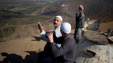 Druze men watch from the Israeli controlled-Golan Heights as Syrian rebels clash with President Bashar Assad’s forces. (File: AP)