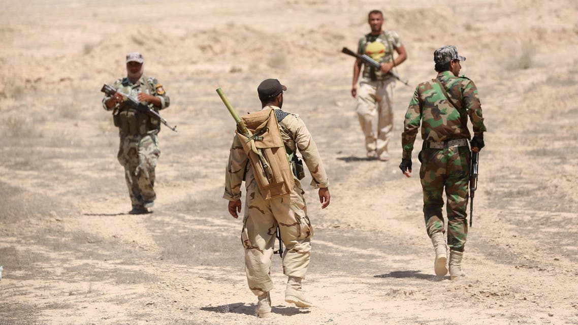 Fighters from the Badr Brigades Shiite militia patrol at the front line, in Kessarrat, located (70 kilometers) north west of Baghdad, Iraq, Friday, June 12, 2015.