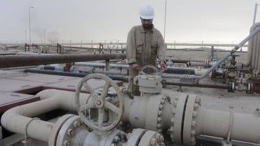 A worker checks the valve of an oil pipe at Rumaila oilfield in Basra, southeast of Baghdad, Iraq June 6, 2015. REUTERS