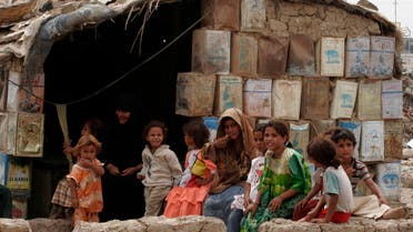 A family group is seen outside their home, which is constructed with mud and tin cans in the Dora neighborhood of Baghdad, Iraq, on Monday, Sept. 8, 2008. (AP Photo/ Loay Hameed)