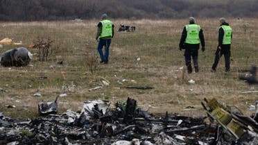 MH17 flight recovery team members examine one of the areas of the Malaysia Airlines Flight 17 plane crash in the village of Hrabove, Donetsk region, eastern Ukraine Tuesday, Nov. 11, 2014. (AP Photo/Mstyslan Chernov)