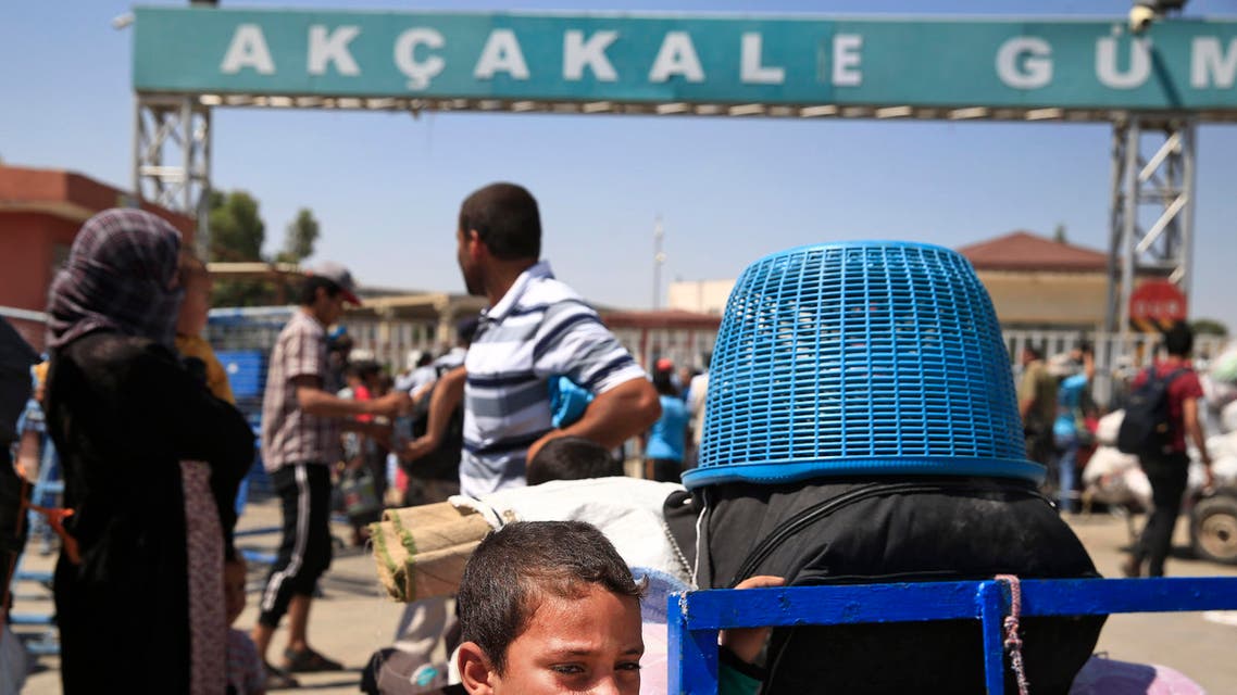 Syrians wait with their belongings to cross back to the border town of Tal Abyad in Syria from Turkey, at the border crossing in Akcakale, southeastern Turkey, Wednesday, June 17, 2015. Some hundreds of Syrians are returning to Tal Abyad from Turkey a day after Kurdish fighters evicted Islamic State group fighters from the area. The Kurdish advance caused the displacement of about 23,000 people who fled into Turkey from the fighting in the past two weeks, according to the UNHCR. (AP Photo/Lefteris Pitarakis)