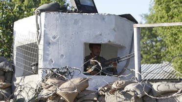 An Afghan policeman keeps watch after a suicide attack on a police headquarters in Jalalabad, Afghanistan June 1, 2015.  (Reuters)