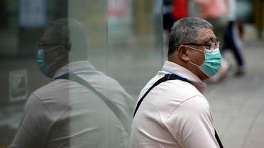 A man wearing a mask as a precaution against Middle East Respiratory Syndrome (MERS) takes a rest at a shopping district in Seoul, South Korea, Thursday, June 11, 2015.