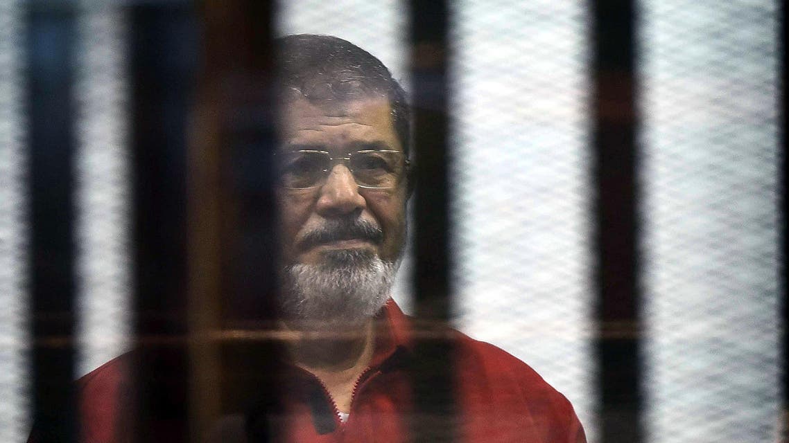 Egypt's ousted Islamist president Mohamed Morsi, wearing a red uniform, stands behind the bars during his trial in Cairo on June 21, 2015. AFP